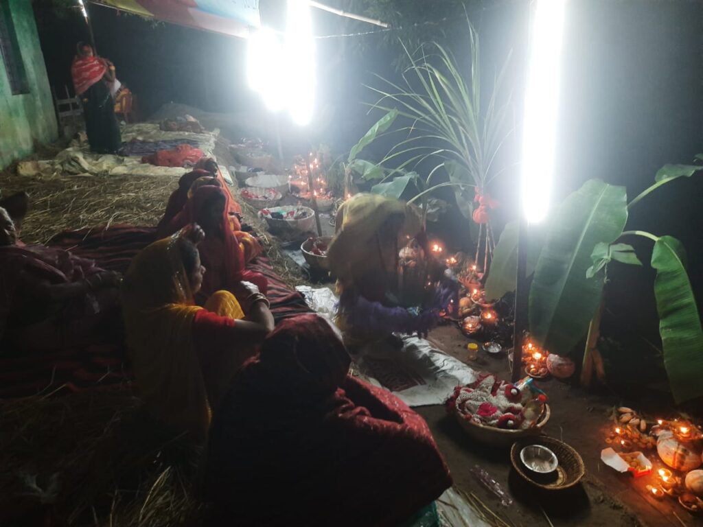Chhath devotees staying awake throughout the night at the Chhath Ghat and lighting an incense stick, candle, and diya